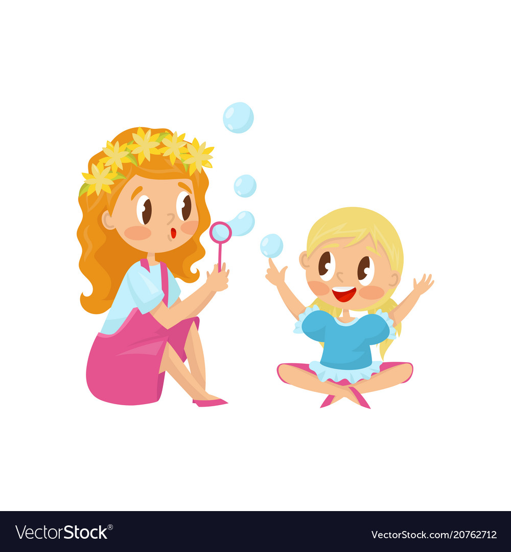 Cute girl blowing soap bubbles with her little