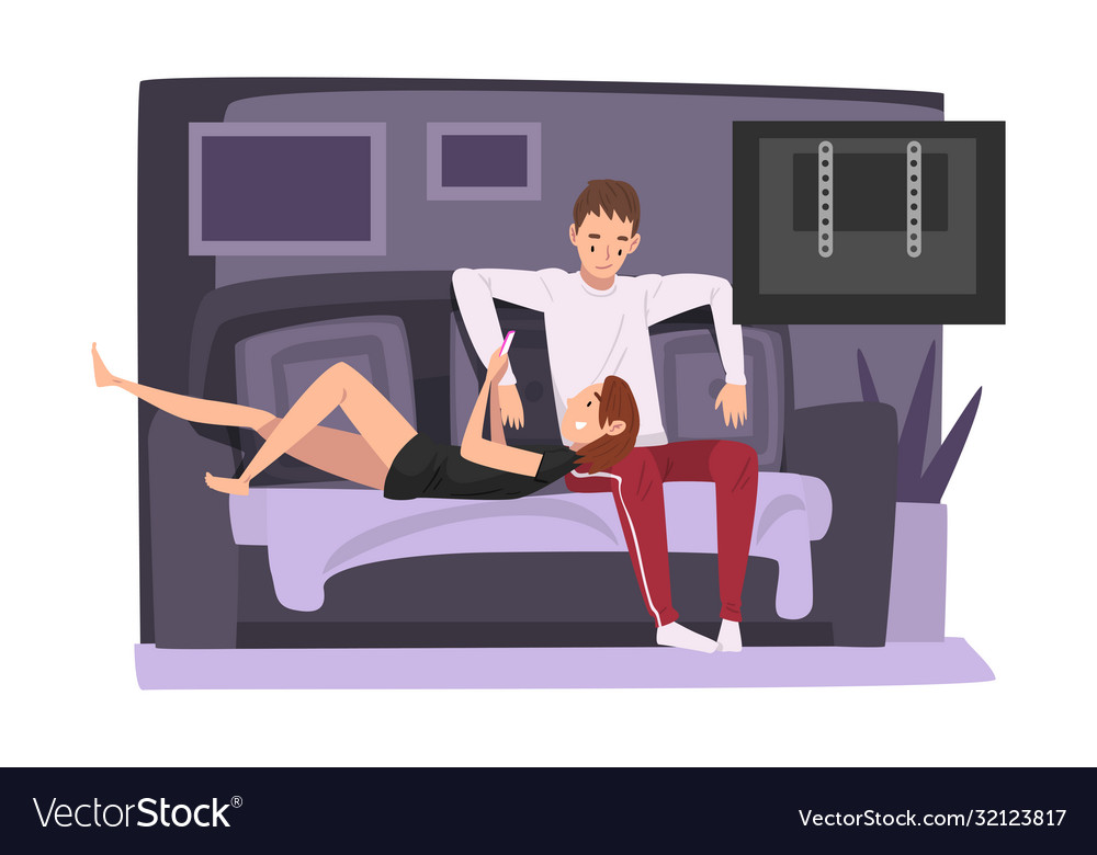 Couple sitting on cozy couch and watching tv