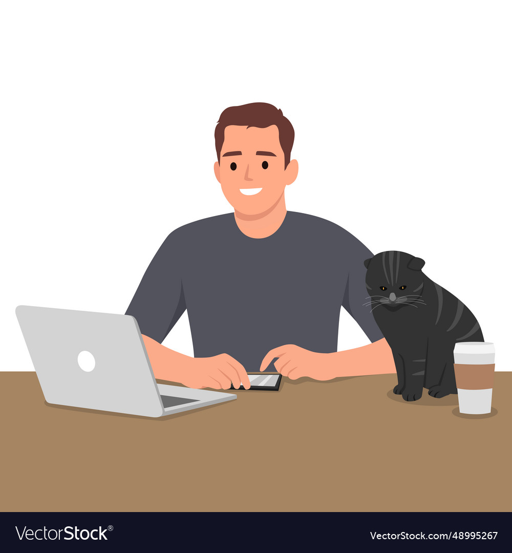 Man working at the table with a cat and coffee