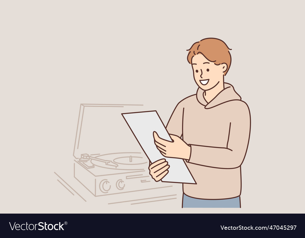 Man with vinyl record stands near gramophone