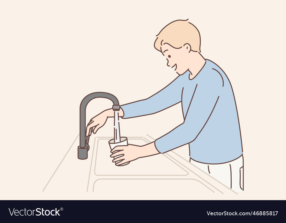 Man draws water into glass from faucet with built