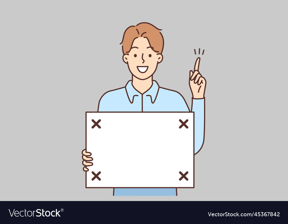 Smiling man with board in hands point up