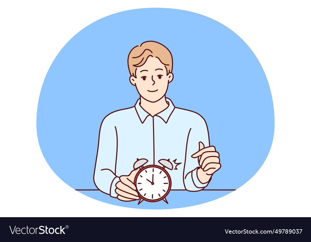 Smiling man points finger at alarm clock to remind