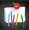 color pencils and apple laying on paper vector image